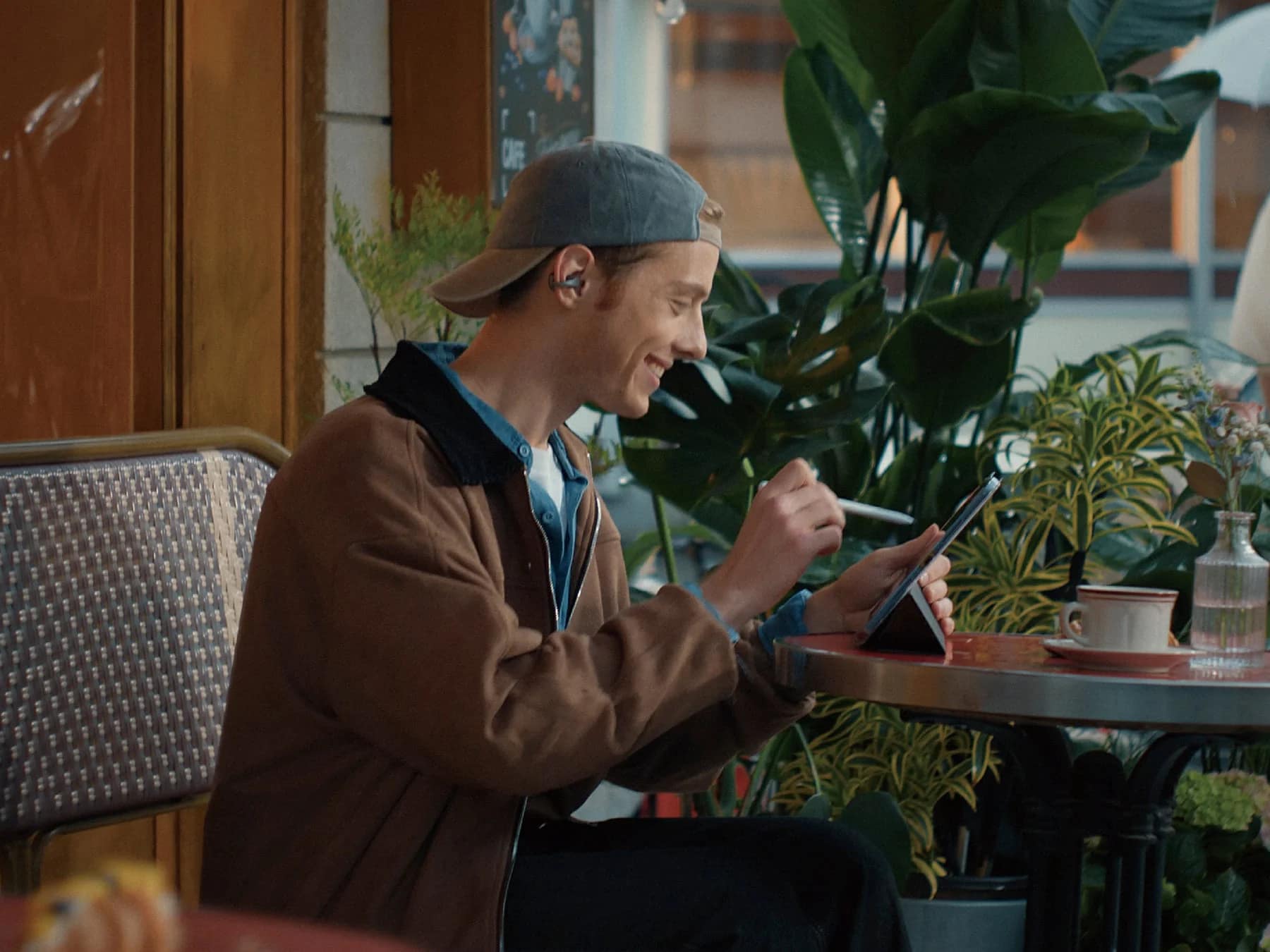 カフェでタブレットとスタイラスペンを使う男性