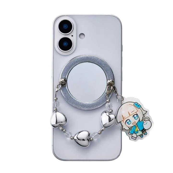白いスマートフォンの背面にミラー付きスマホリングが装着されており、ハート形のビーズとアニメキャラクターのチャームが付いたストラップが取り付けられています