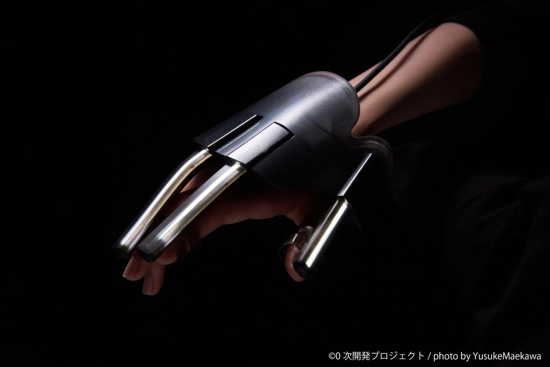 人の手に装着された、未来的なデザインのウェアラブルデバイス