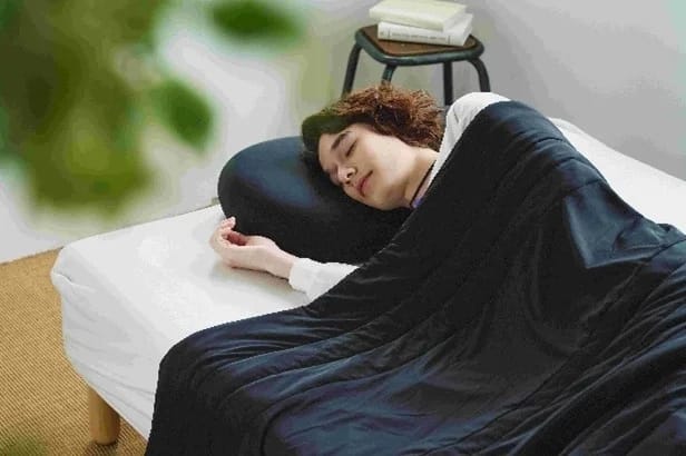 若い男性がベッドで横向きに眠っており、安らかな表情を見せている。